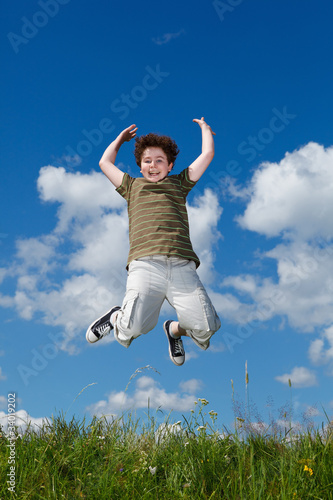 Boy jumping  running against blue sky