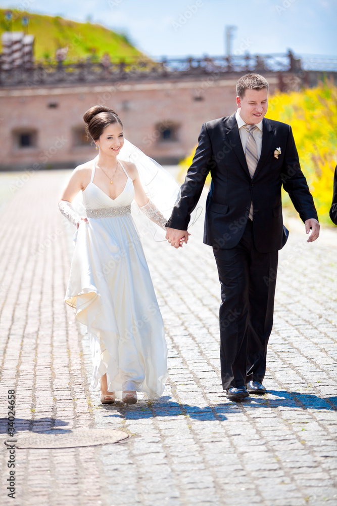 Naklejka premium Young just married couple walking holding hands