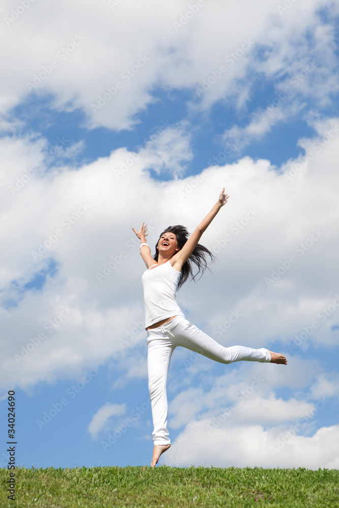 pretty young woman jumping on green grass