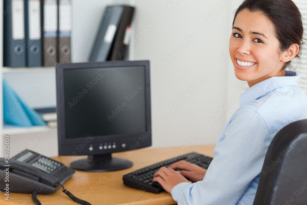 View from behind of a good looking woman typing on a keyboard wh View from behind of a good looking woman typing on a keyboard wh