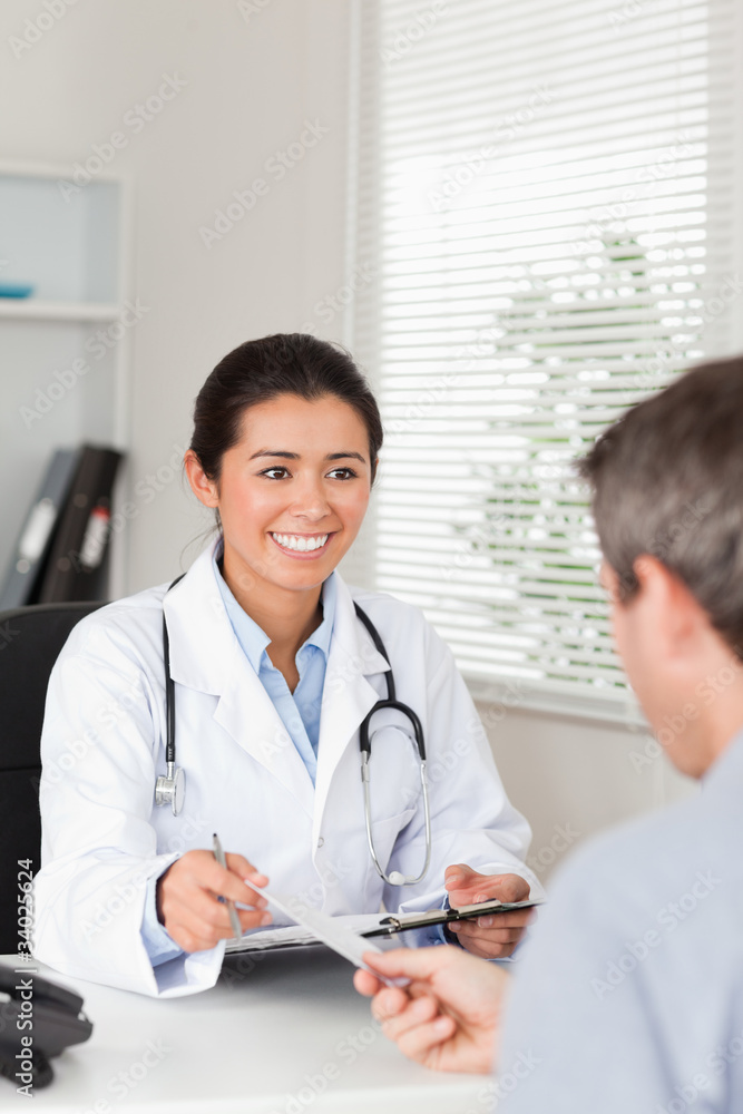 © WavebreakmediaMicro - Patient giving his pretty woman doctor a piece of paper