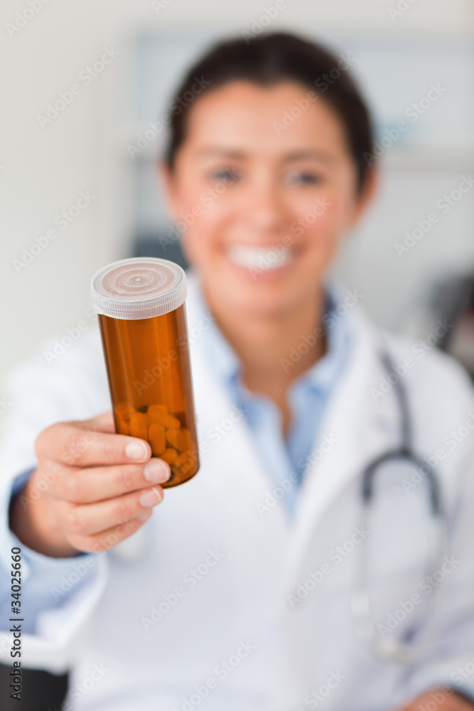 Portrait of an attractive smiling doctor holding a box of pill Portrait of an attractive smiling doctor holding a box of pill