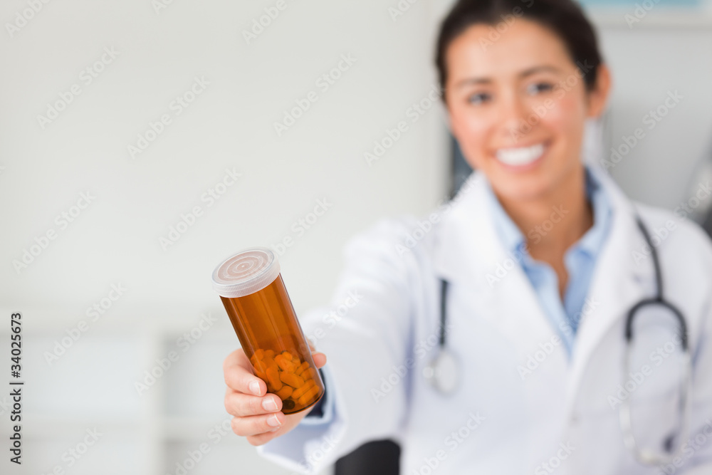 Gorgeous smiling doctor holding a box of pills Gorgeous smiling doctor holding a box of pills