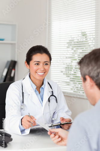 Patient giving his pretty woman doctor a piece of paper