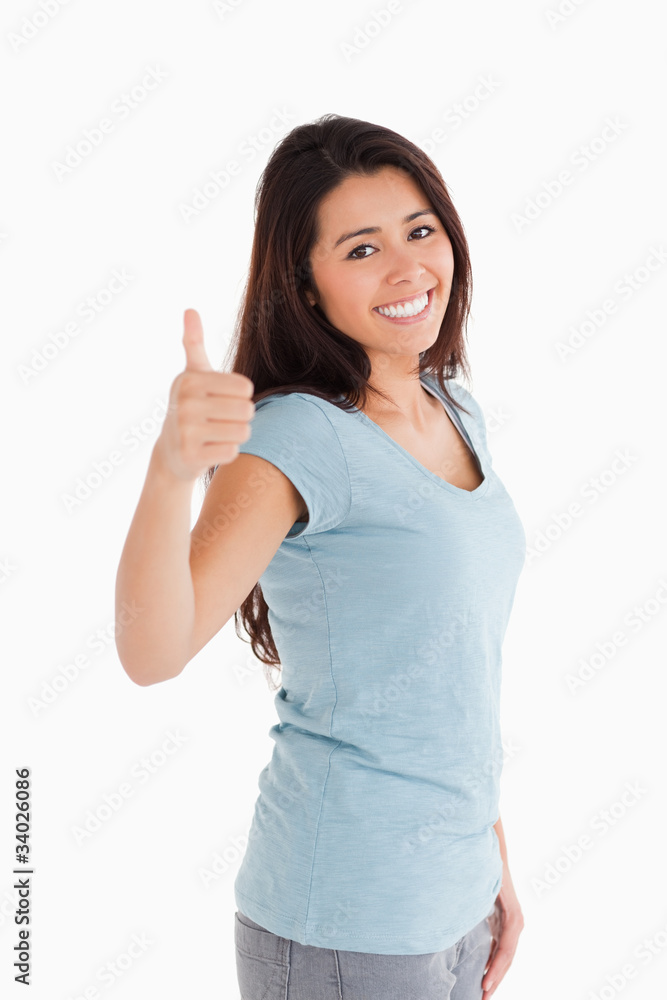 Beautiful woman having her thumb up while standing Beautiful woman having her thumb up while standing
