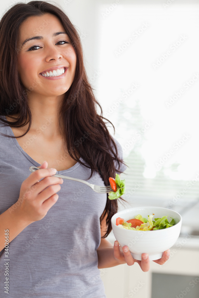 Pretty woman enjoying a bowl of salad while standing Pretty woman enjoying a bowl of salad while standing