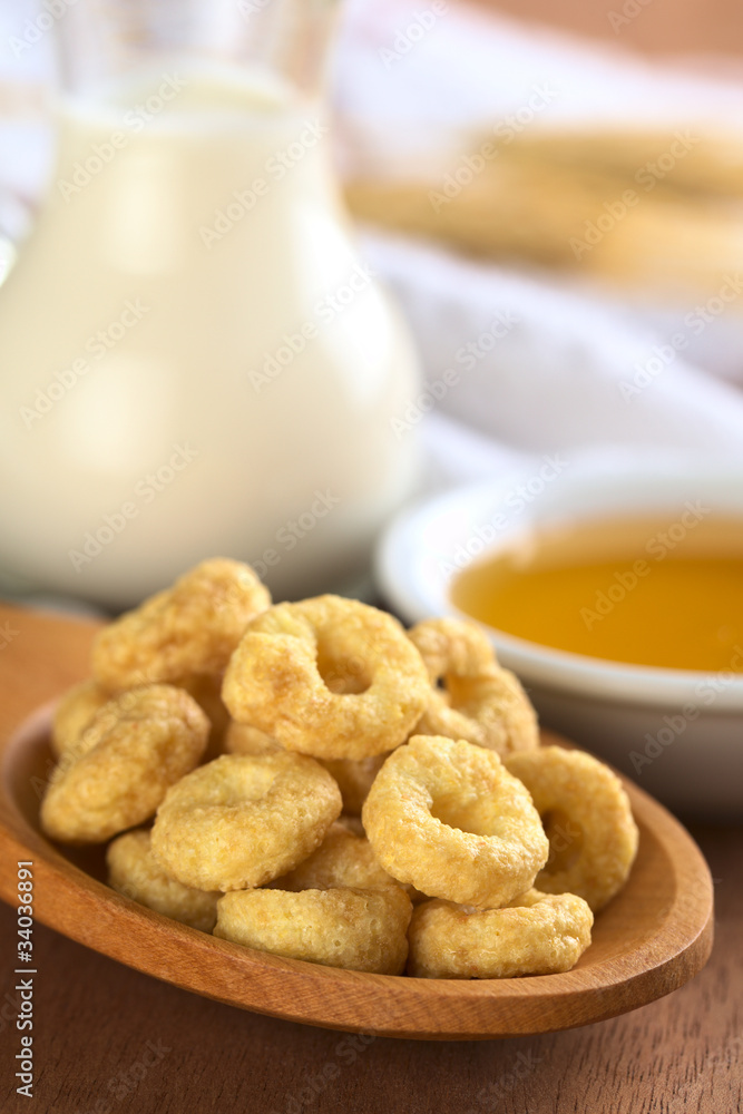 Honey flavoured cereal loops on wooden spoon Honey flavoured cereal loops on wooden spoon