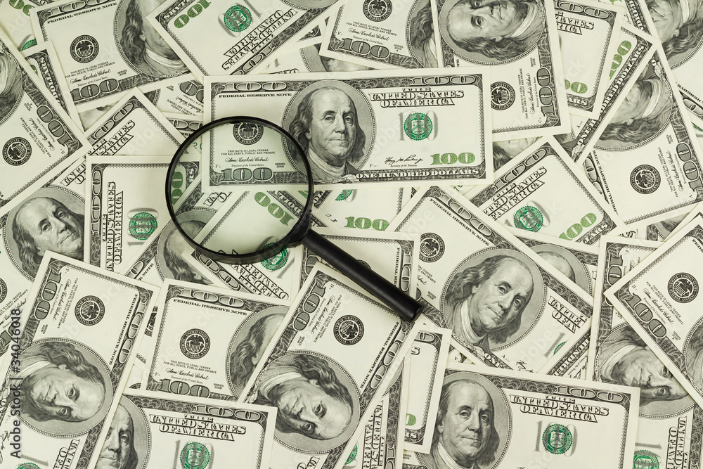 magnifying glass against the U.S. dollar magnifying glass against the U.S. dollar