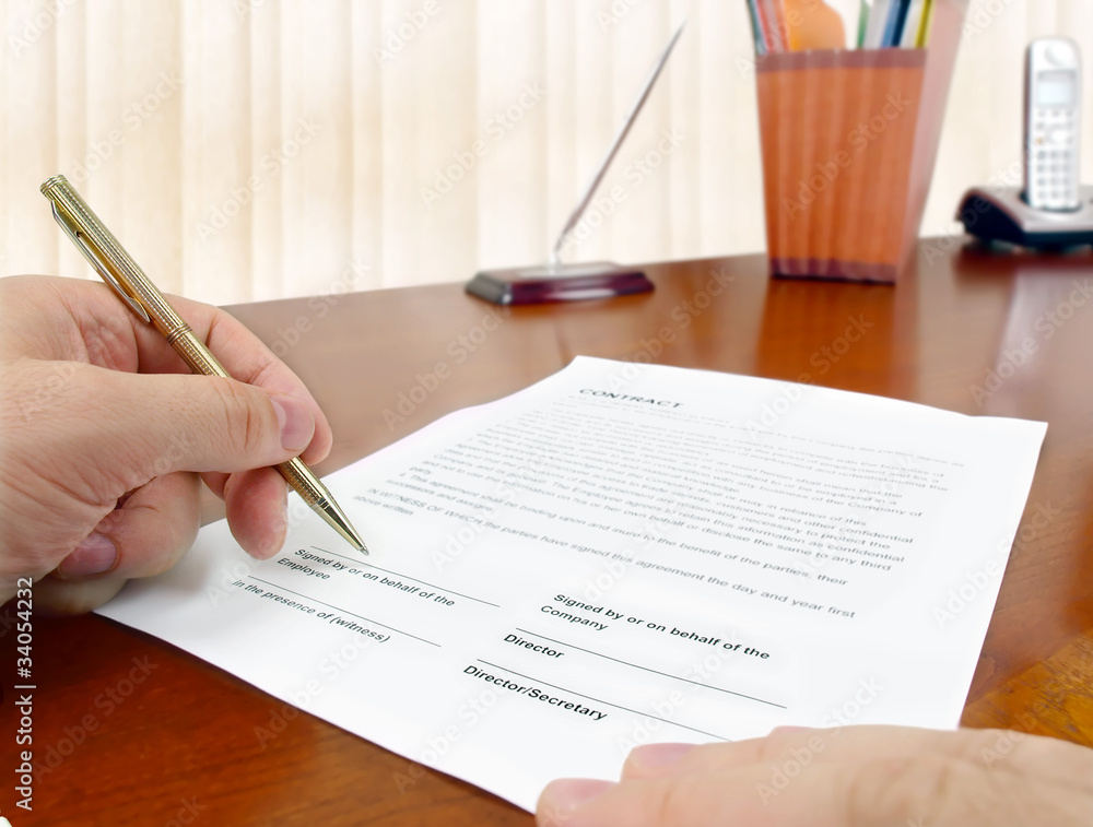 Male hand with pen signing a contract. Male hand with pen signing a contract.