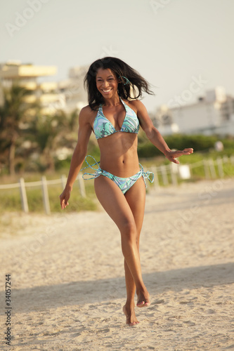 Happy woman in a bikini running on the beach