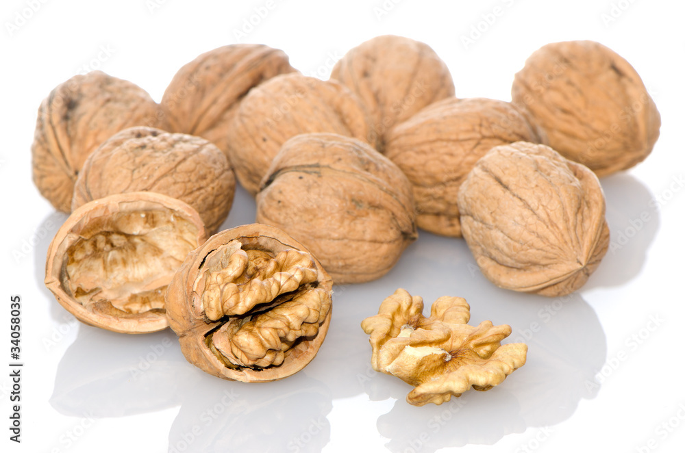 Walnuts a shell on a white reflective background. Walnuts a shell on a white reflective background.