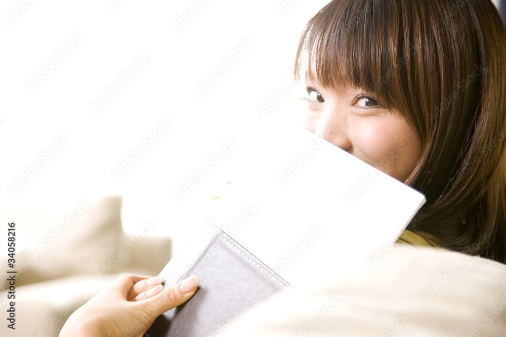 本で顔を隠す女性 本で顔を隠す女性