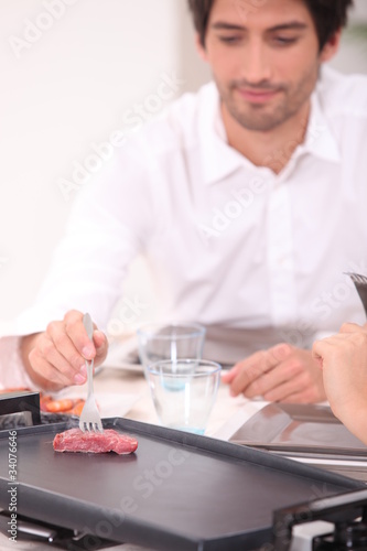 Man cooking on a table top plancha