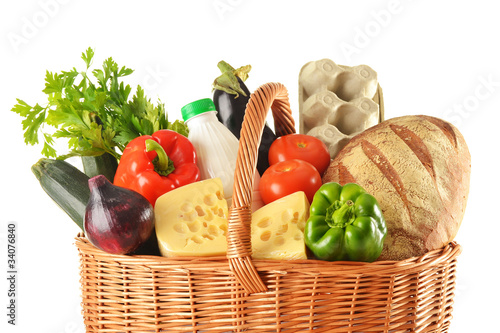 Groceries in wicker basket isolated on white
