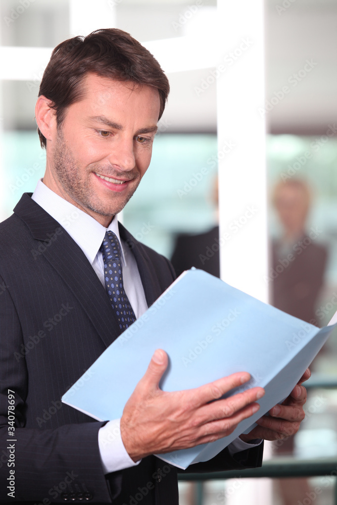 Happy executive reading a report