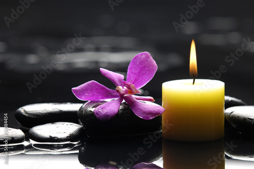 spa scene -aromatherapy candle and pink orchid on zen stones