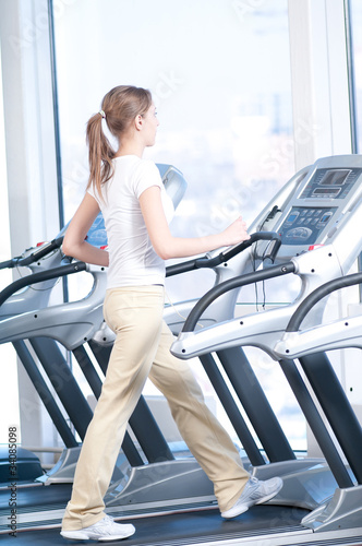 Young woman at the gym exercising. Running