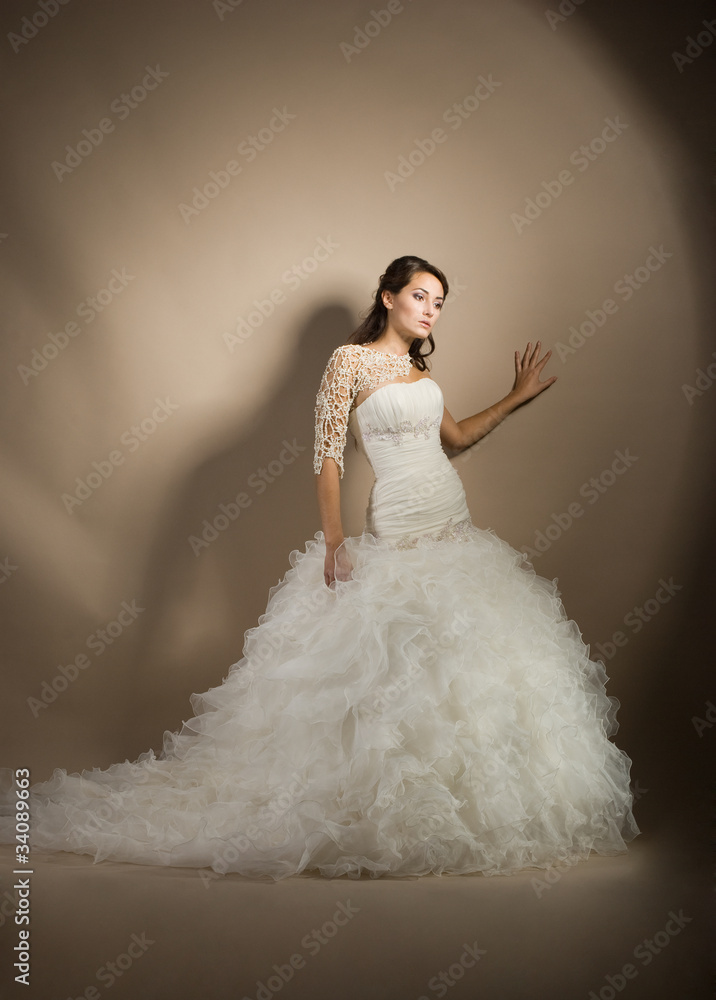 Naklejka premium The beautiful young woman posing in a wedding dress