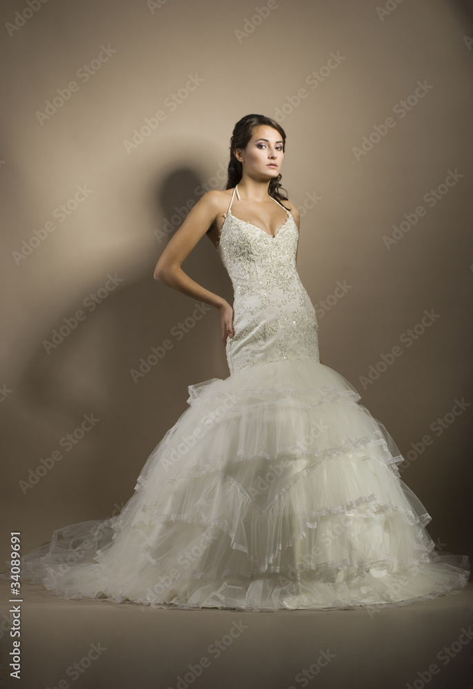 The beautiful young woman posing in a wedding dress The beautiful young woman posing in a wedding dress