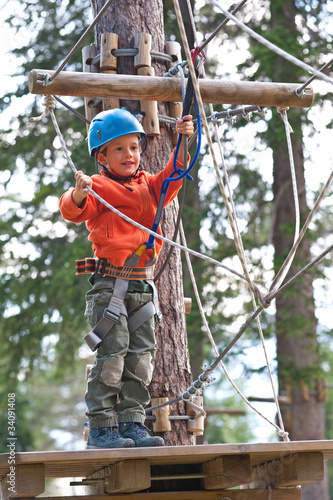 Kid climbing trees in Dolomites, Italy.