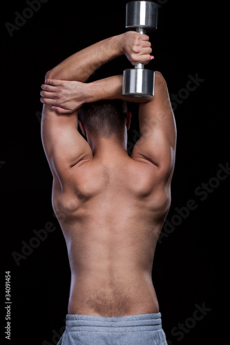 Male back doing fit exersices with dumbbell