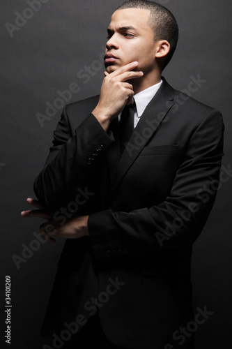 Young  African-American business man in black suit. © Mirma