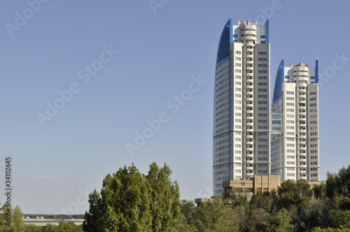 Modern building on sky background with trees and river © Veronika