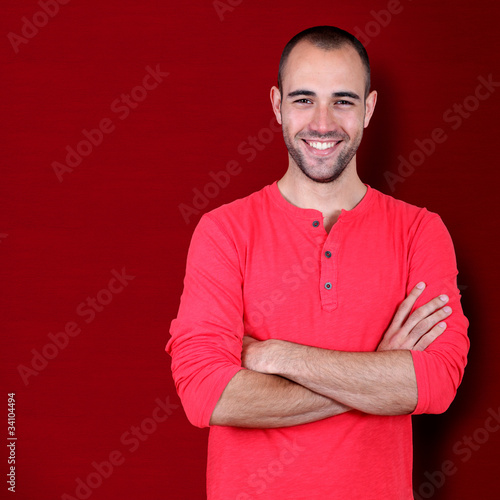Handsome man standing on red background © goodluz