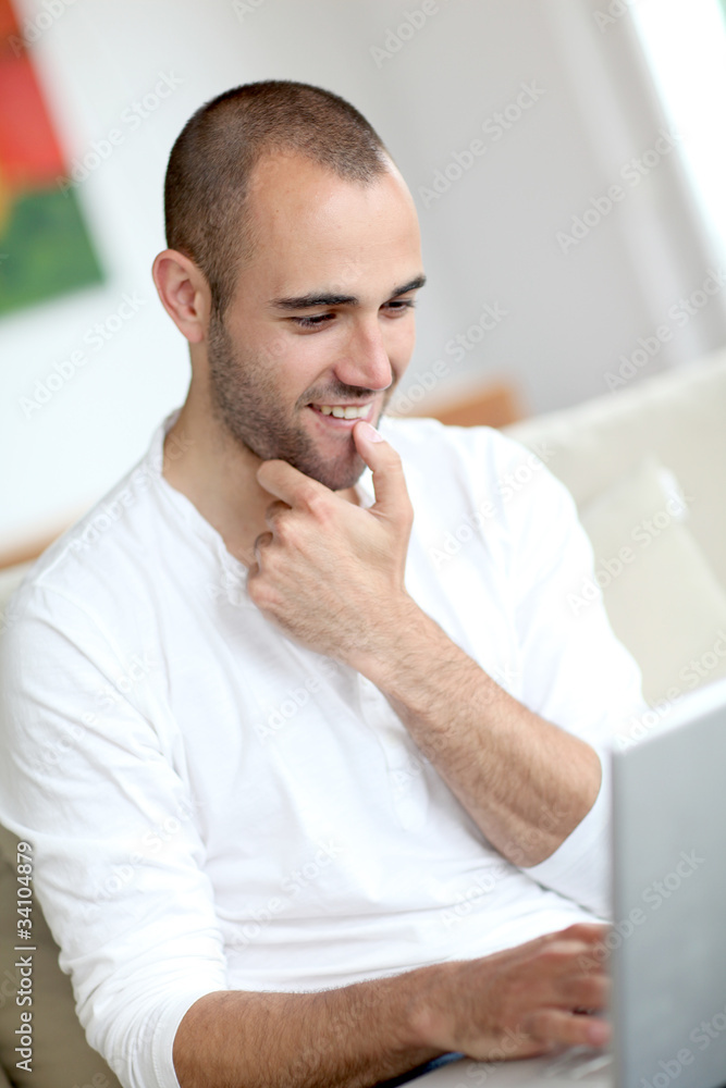 Closeup of handsome man websurfing on laptop computer