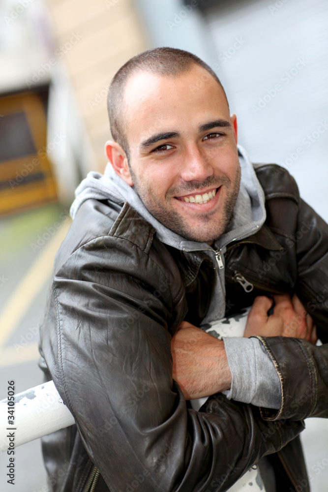 Smiling young man with leather jacket in town Smiling young man with leather jacket in town