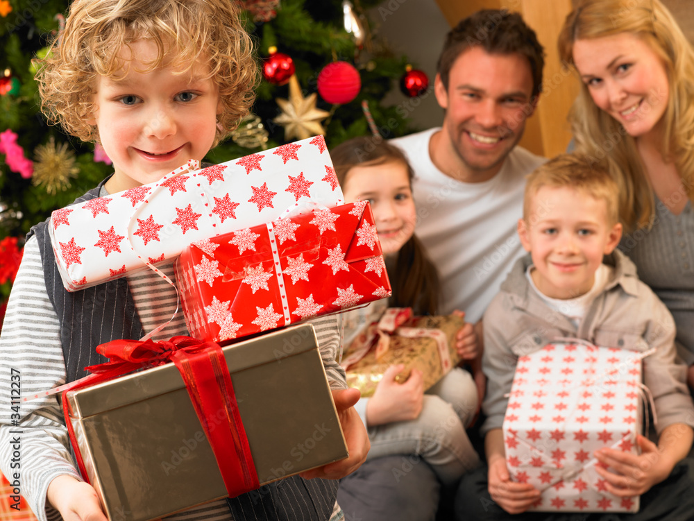 Family with gifts in front of Christmas tree Family with gifts in front of Christmas tree