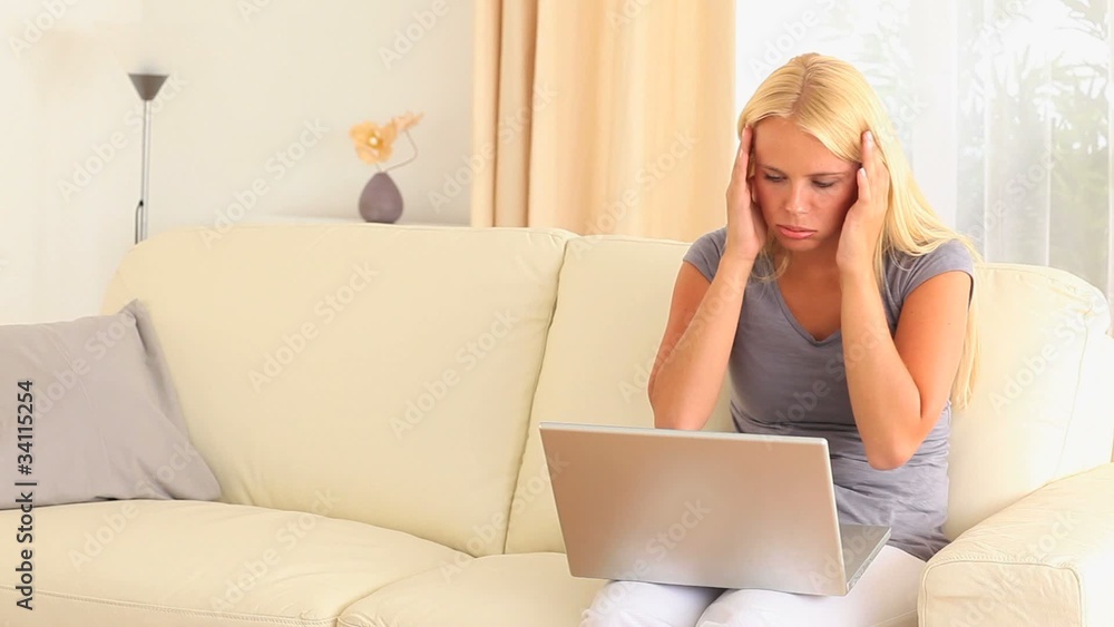 Stressed and frustrated woman sitting on a sofa Stressed and frustrated woman sitting on a sofa