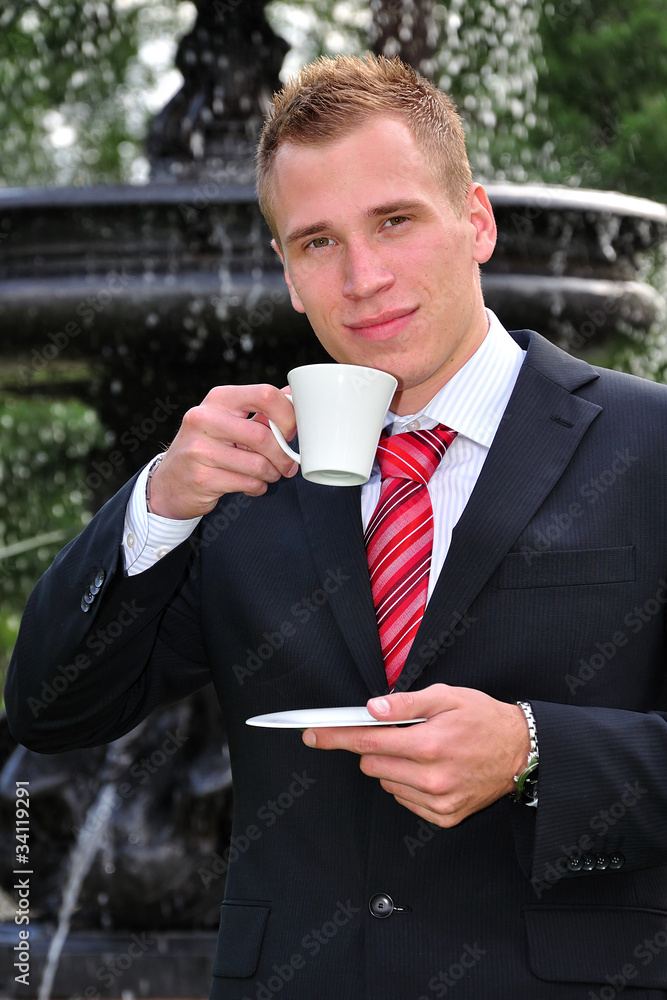 Young man in suit with cup of coffee Young man in suit with cup of coffee
