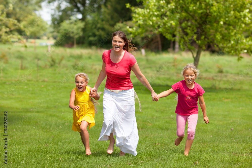 family woman and girls running outdoor smiling
