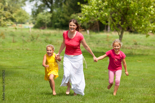 family woman and girls running outdoor smiling