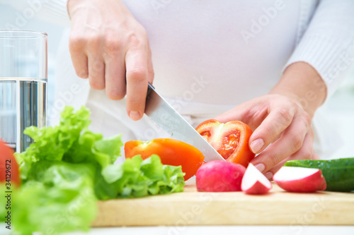 Hands cooking vegetables salad