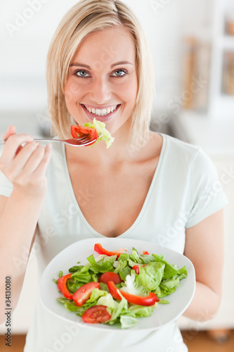 Charming woman eating salad