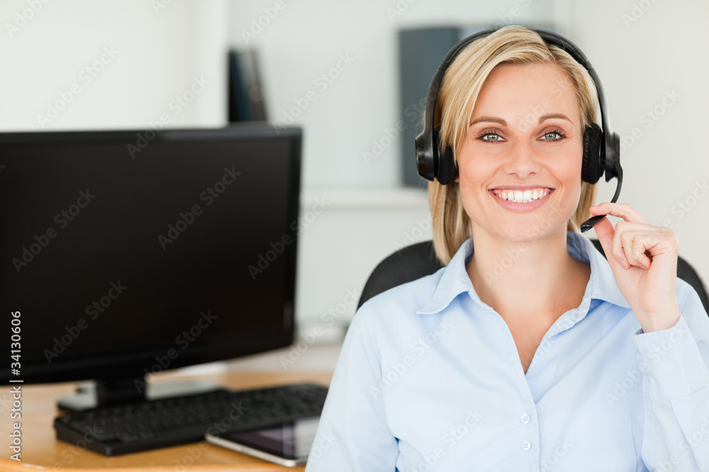 Close up of a blonde smiling woman wearing headset looking into Close up of a blonde smiling woman wearing headset looking into