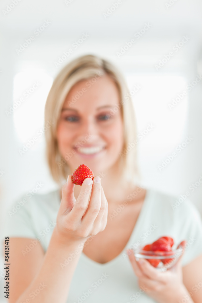 Woman looking at strawberry with pleasure Woman looking at strawberry with pleasure