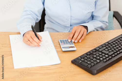 Female accountant writing results on a piece of paper