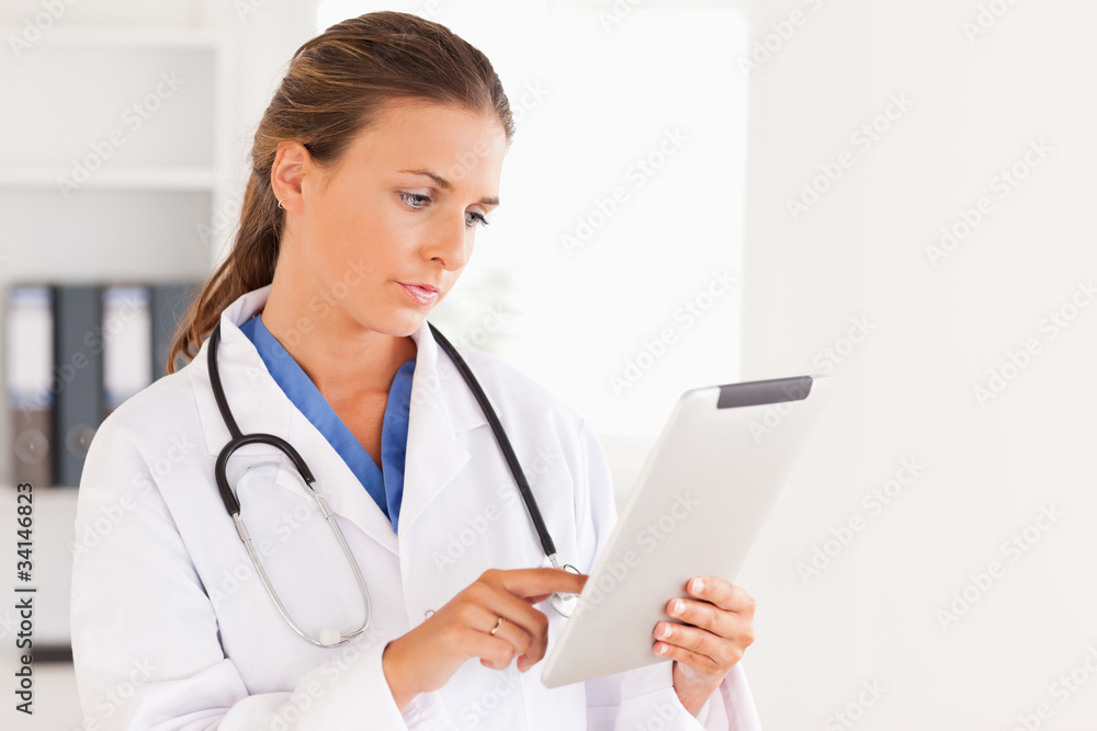 Charming doctor having a stethoscope around her neck looking at Charming doctor having a stethoscope around her neck looking at
