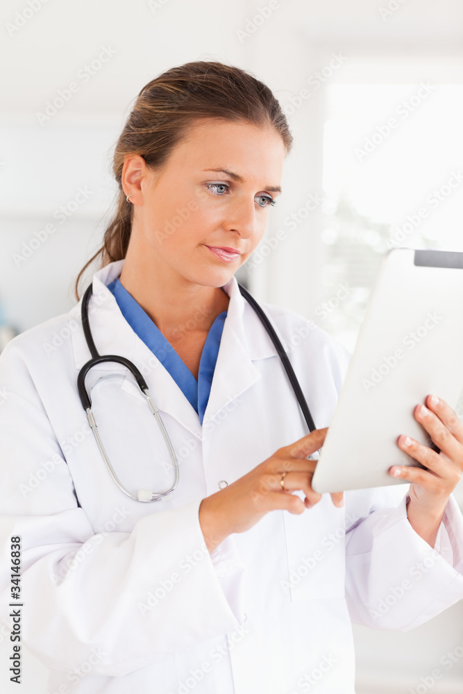 Charming doctor with a stethoscope pointing at a file Charming doctor with a stethoscope pointing at a file
