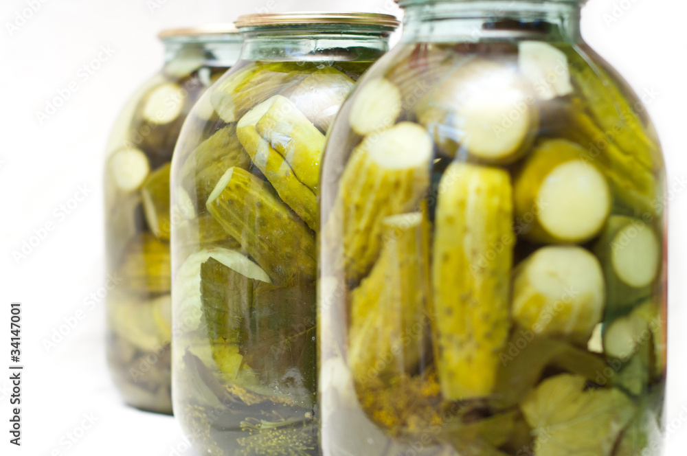 Row of jars with pickles. Focus on the middle one Row of jars with pickles. Focus on the middle one