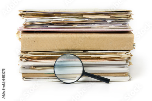Magnifying lens  on the background of the stack of old files