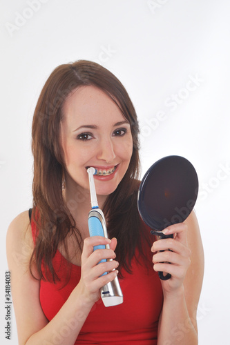 girl cleaning teeth with electric toothbrush
