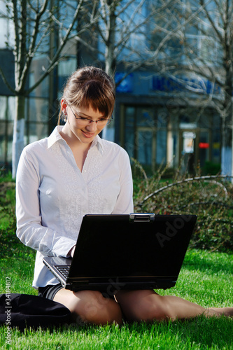 Woman lying on grass with laptop