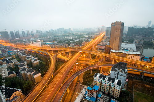 Freeway in night with cars light in modern city.