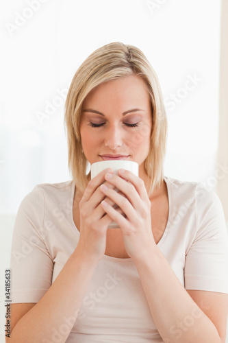 Portrait of a woman smelling her cup of coffee