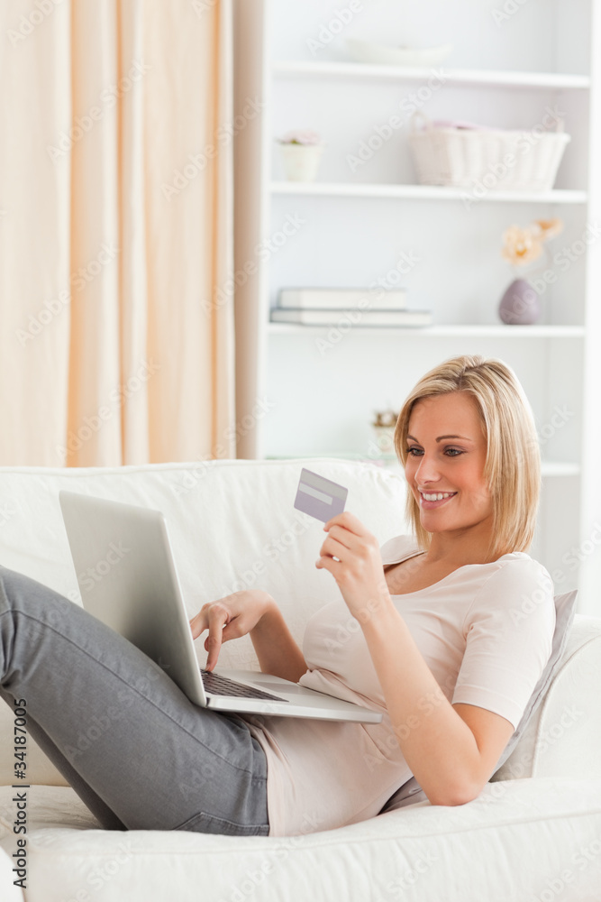 Portrait of a woman buying online whilie lying on a couch Portrait of a woman buying online whilie lying on a couch