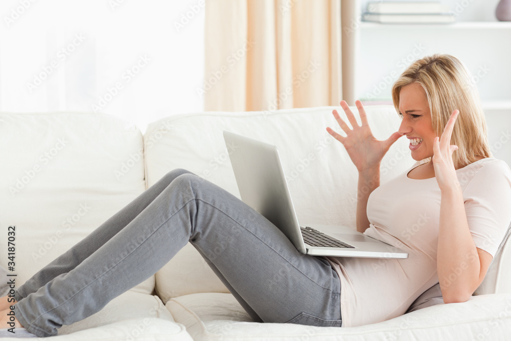 Unhappy blonde woman having trouble with her laptop Unhappy blonde woman having trouble with her laptop